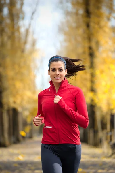 Female athlete running in autumn — Stock fotografie