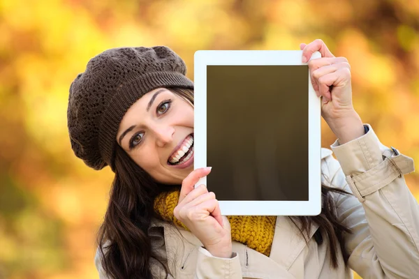 Surprised woman showing digital tablet screen in autumn — Stock Photo, Image