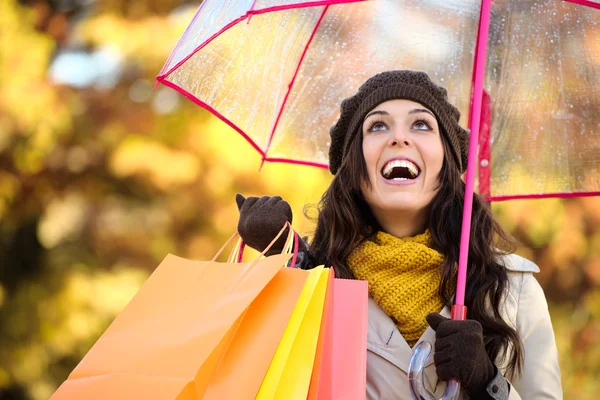 Frau mit Einkaufstaschen und Regenschirm im Herbst — Stockfoto