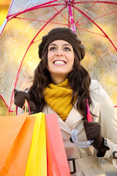 Mulher com sacos de compras e guarda-chuva na temporada de outono — Fotografia de Stock