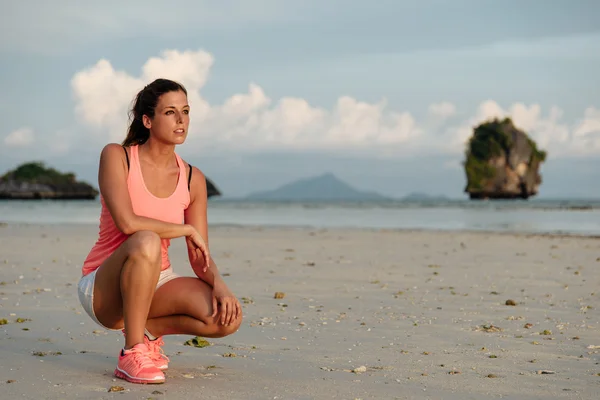 Motivated sporty woman before running at beach — Stock Photo, Image