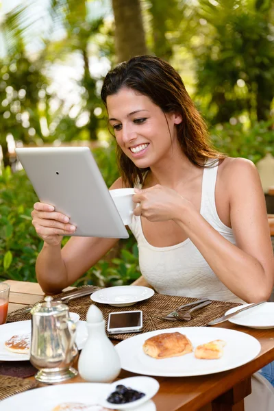 Kahvaltı açık ve kullanma dijital tablet olan kadın — Stok fotoğraf