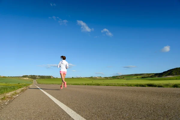 Atleta feminino correndo na estrada — Fotografia de Stock