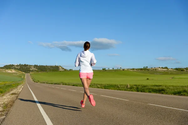 Женщина бежит по дороге — стоковое фото