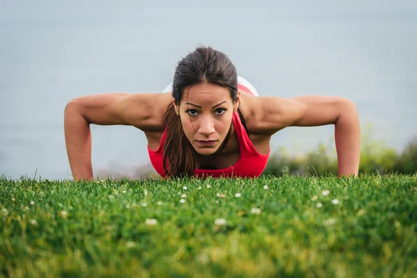 Mujer fuerte en forma haciendo flexiones —  Fotos de Stock