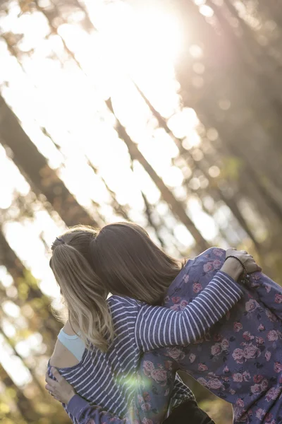 Две девушки обнимаются и опираются друг на друга — стоковое фото