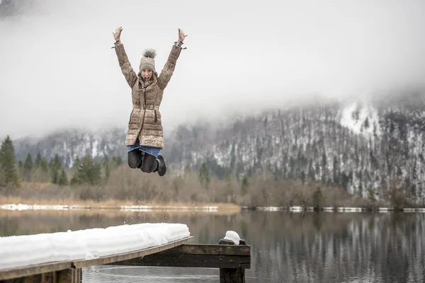 Woman in mid-air jumping near lake — Stock Photo, Image