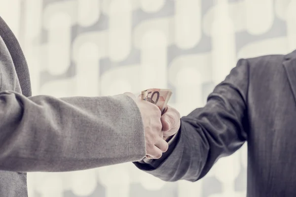 Closeup of one businessman giving money or bribe to the other — Stock Photo, Image