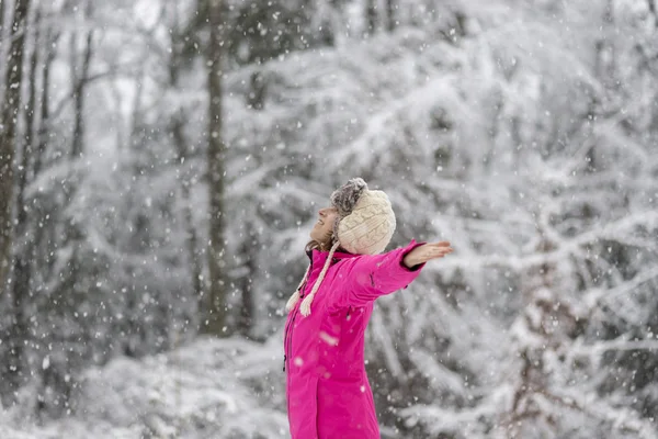 Jovem feliz de pé na neve nevasca com os braços estendidos — Fotografia de Stock