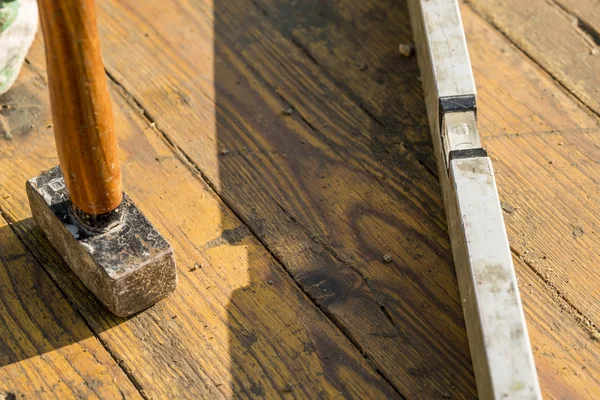 Close-up de um martelo e construtores nível deitado sobre pla de madeira suja — Fotografia de Stock