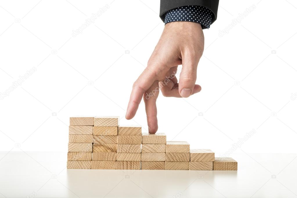 Male hand in business suit walking its fingers up a staircase