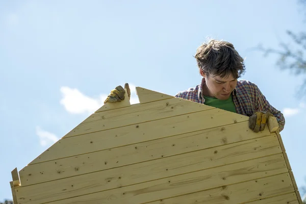 Vista de ángulo bajo de un joven montando una casita de madera —  Fotos de Stock