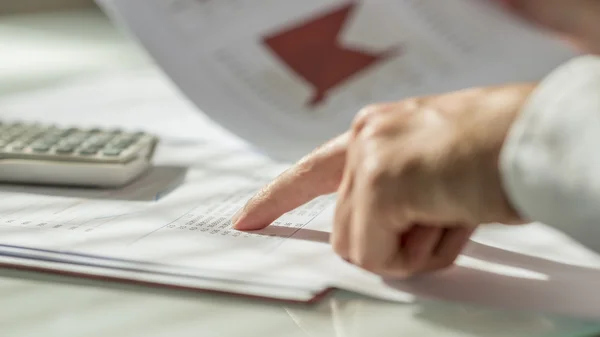 Closeup of male hand pointing to figures written on a document — Stock Photo, Image