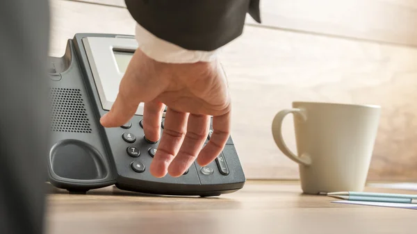 Låg vinkel syn på en affärsman hand ringa upp telefonnummer på — Stockfoto