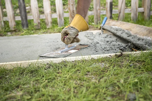 Man with protective gloves levelling the surface of a concrete p — Stock Photo, Image
