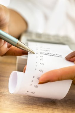 Kadın muhasebeci bir çıktı veya r kontrol ederek çalışma closeup