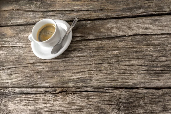 Media taza llena de café con cuchara en la mesa de madera — Foto de Stock