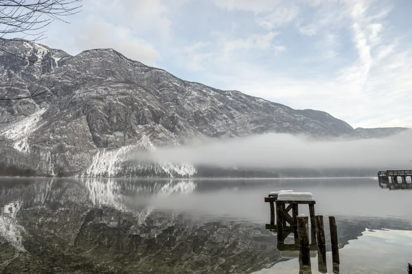 Niebla rodando en el agua bajo las montañas — Foto de Stock