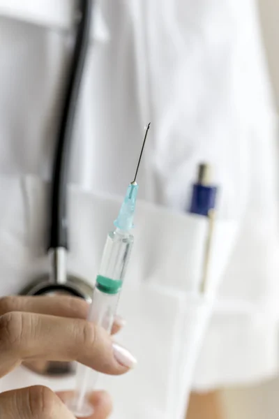 Médico segurando uma seringa para cima — Fotografia de Stock