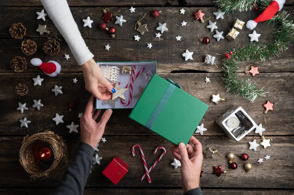 Yeşil Bir Tatil Kutusunu Noel Süslemeleriyle Dolu Bir Masada Paketleyen — Stok fotoğraf