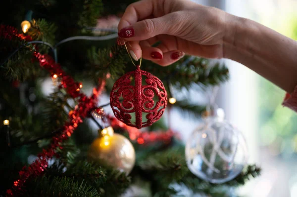 Nahaufnahme Der Weiblichen Hand Die Leuchtend Rote Weihnachtsbaumkugel Weihnachtsbaum Hängt — Stockfoto