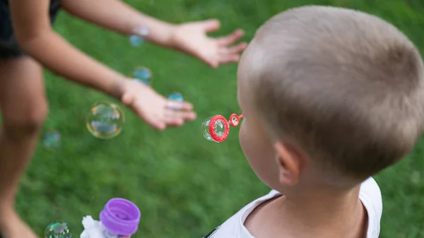 Peuter Jongen Blaast Soep Bubbels Buiten Voor Zijn Broer Jagen — Stockfoto