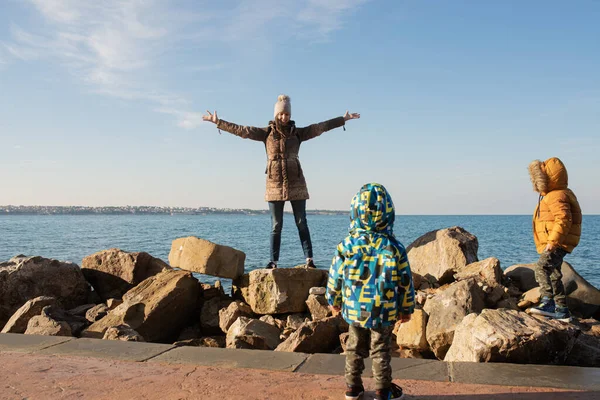 Šťastná Mladá Matka Stojící Skalách Zimního Moře Rukama Široce Roztaženýma — Stock fotografie