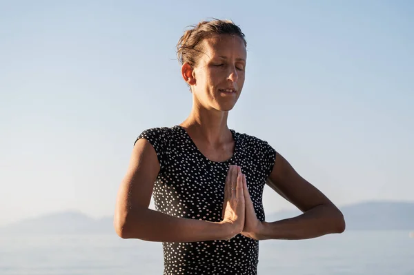 Ellerinin Avuçlarıyla Deniz Kenarında Meditasyon Yapan Genç Bir Kadın — Stok fotoğraf