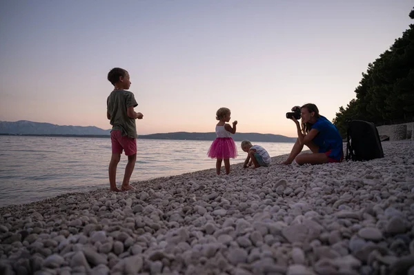 Νεαρή Μητέρα Φωτογραφίζει Τρία Παιδιά Της Παίζοντας Στην Παραλία Βότσαλα — Φωτογραφία Αρχείου