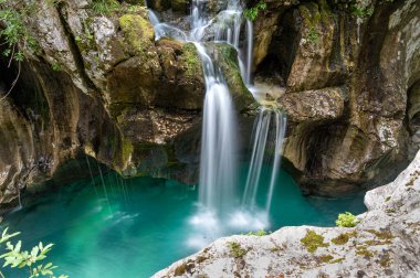 Yosunlu kayalardan dökülen güzel dere Soca 'nın turkuaz nehrine dökülüyor..