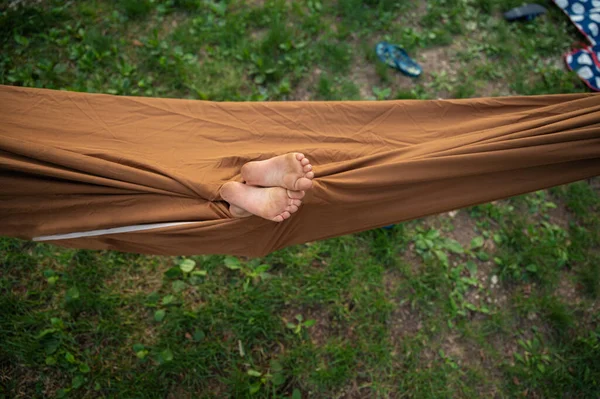 Yeşil Çimlerin Üzerinde Kahverengi Bir Hamak Gören Iki Çocuk Ayağı — Stok fotoğraf