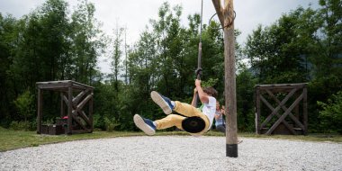 Anne ve oğlu parkta eğleniyor. Parkın dışında salıncak gibi özel bir atlıkarıncaya biniyorlar..