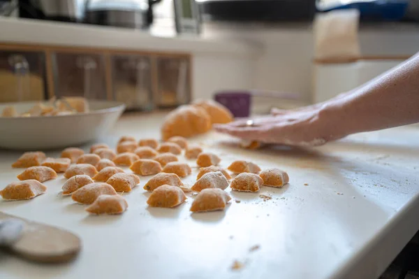 伝統的なイタリアのパスタ餃子を作るために新鮮なビーガン自家製ニョッキ生地を圧延女性の低角度ビュー — ストック写真