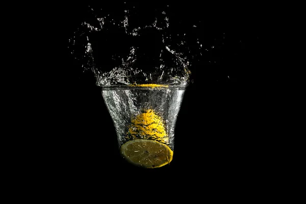 Dimezzato limone fresco spruzzando in acqua pulita — Foto Stock