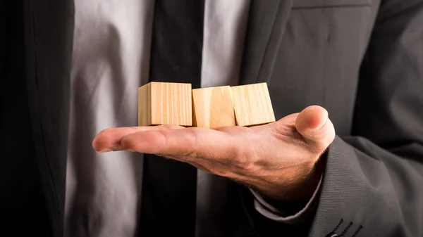 Бизнесмен с тремя пустыми деревянными кубиками — стоковое фото
