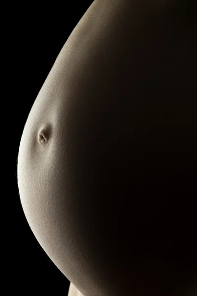 Bare belly of a very pregnant woman — Stock Photo, Image