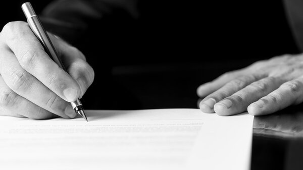 Man writing or signing a document