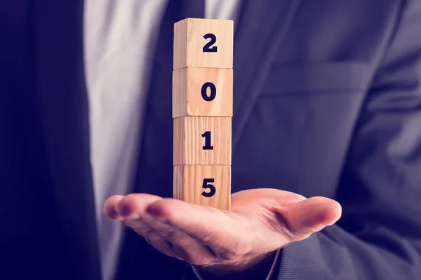 Geschäftsmann hält hölzerne Neujahrsblöcke — Stockfoto