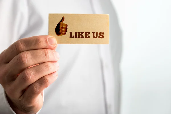 Man displaying a card saying - Like Us — Stock Photo, Image