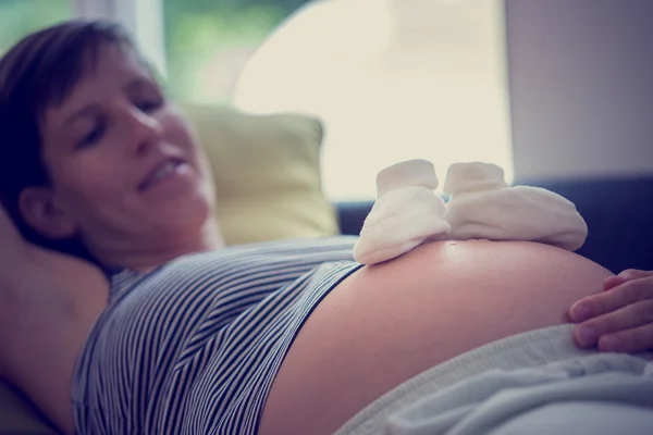 Calcetines blancos para bebés en la barriga de la mujer embarazada —  Fotos de Stock