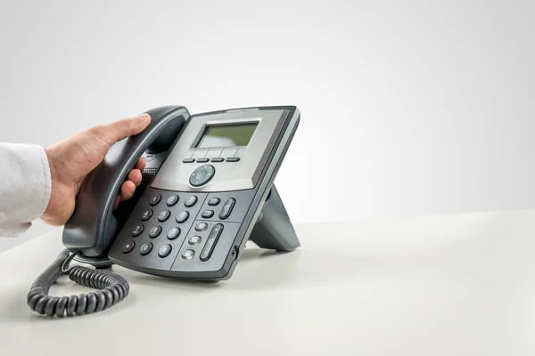 Empresario haciendo una llamada telefónica por teléfono fijo —  Fotos de Stock