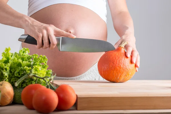 Беременная женщина режет свежие овощи Лицензионные Стоковые Фото