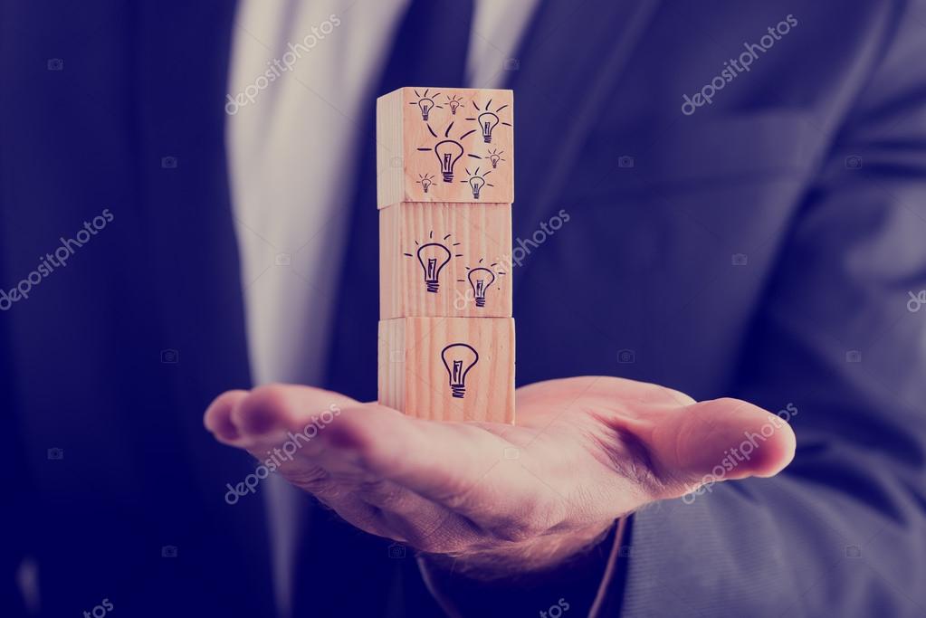 Herunterladen - Geschäftsmann mit drei hölzernen Würfeln vertikal ausgerichtet, mit handgezeichneten Glühbirnen, Konzept kreativer Ideen und neuer Geschäftsprojekte. — Stockbild Geschäftsmann hält Würfel mit gezogenen Glühbirnen — Stockfoto