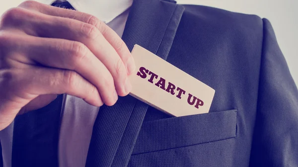 Businessman removing a wooden card reading Start up from his poc — Stock Photo, Image