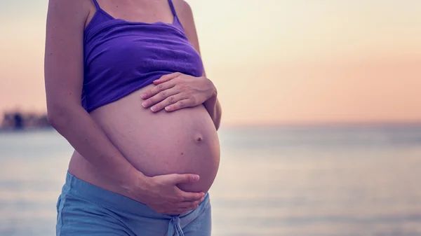 Retro image of pregnant woman on a beach — Stock Photo, Image