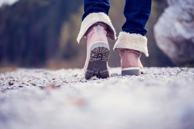 Kadın kırsal bir yol boyunca yürüyüş botları