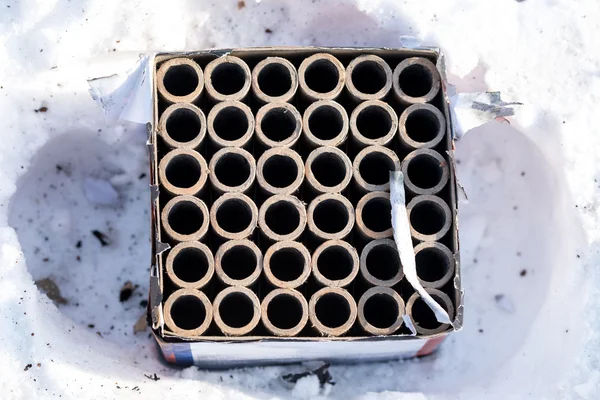 Fuegos artificiales usados petardos que yacen en la nieve —  Fotos de Stock