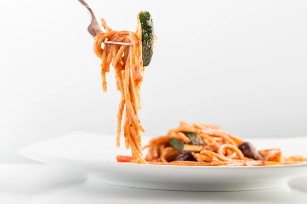 Spaghetti with tomato sauce and courgette on a fork — Stock Photo, Image