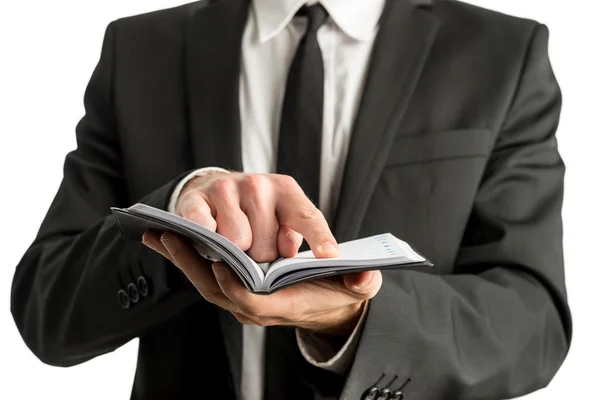 Närbild av en affärsman hålla liten anteckningsbok eller planner — Stockfoto