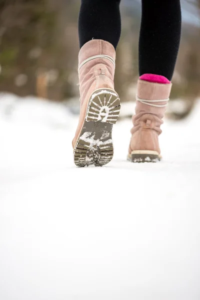 Mujer alejándose de la cámara a través de la nieve de invierno — Foto de Stock